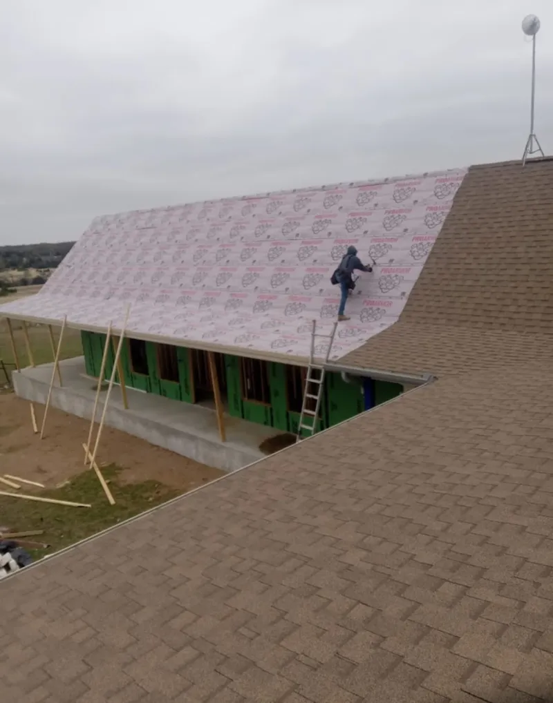 Worker preparing underlayment for a metal roof installation in Key West